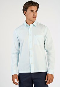 Lichtblauwe overhemd met lange mouwen, button-down kraag, borstzak, witte knopen en een rechte onderrand. Lichtgewicht stof en een gladde textuur.