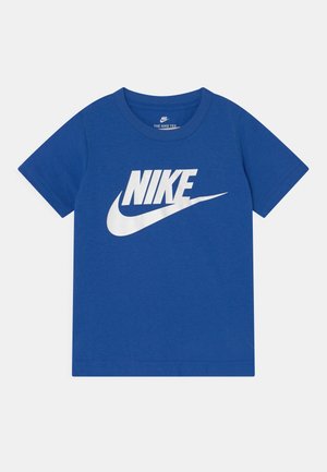 Niebieska koszulka Nike z krótkim rękawem, z dużym białym napisem „NIKE” oraz logo Swoosh umieszczonym na środku przodu.