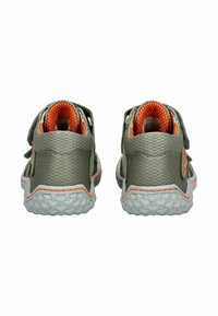 Zapatos para niños con un exterior de malla gris, forro naranja y correas ajustables de Velcro. Suela de goma blanca con textura en la plantilla.