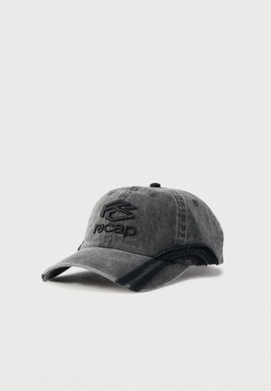 Casquette de baseball noire usée avec une visière courbée, un logo "recap" brodé en noir, et de fines rayures noires sur le côté.
