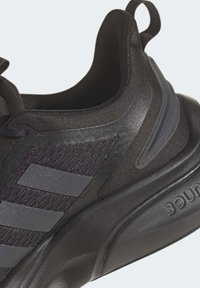 Scarpa da ginnastica nera con una tomaia texturizzata, tre strisce grigio scuro, intersuola ammortizzata e un tab al tallone.