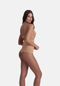 Naadloze nude shapewear set met verstelbare bandjes, een gladde afwerking en een hoogoplopende taille voor lichaamcontourering.