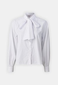 Blusa bianca a maniche lunghe con colletto a fiocco. Realizzata in tessuto liscio, presenta una chiusura con bottoni e polsini aderenti. Design minimalista.