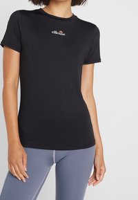 Svart, figurnära t-shirt i mjukt,stretchigt material. Har en liten logo på bröstet och korta ärmar. Snyggt accentuerad med en rund halsringning.