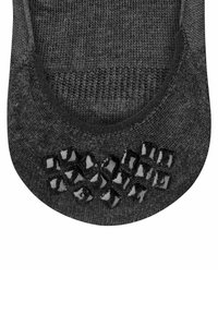 Schwarze Knöchelsocke mit strukturiertem Grip an der Ferse, hergestellt aus einem weichen, dehnbaren Material mit einem glatten Strickmuster und Gummielementen.