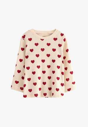 Strikket sweater med en cremefarvet baggrund og røde hjerte mønstre. Har en rund halsudskæring og trekvart lange klokkeærmer.