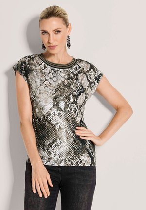 Korte mouwen top met een zwart-wit slangendessin, ronde halslijn met groene accenten en een gladde, gestructureerde stof.