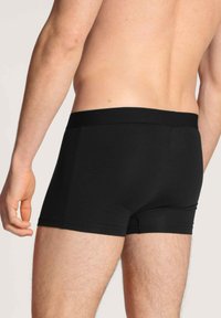 Zwarte boxershorts van zacht, rekbaar materiaal. Bevat een brede elastische tailleband en heeft een aansluitend ontwerp, geschikt voor dagelijks gebruik.