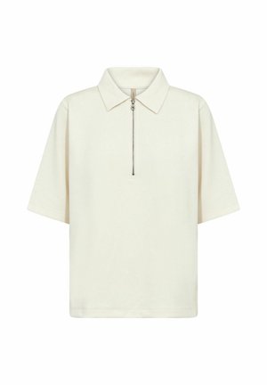 Kremo spalvos trumpomis rankovėmis polo marškinėliai su užtrauktuku priekyje ir klasikiniu apykakle, pateikti ant balto fono.