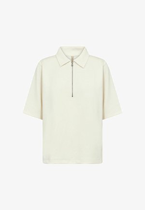 Kremo spalvos trumpomis rankovėmis polo marškinėliai su užtrauktuku priekyje ir klasikiniu apykakle, pateikti ant balto fono.