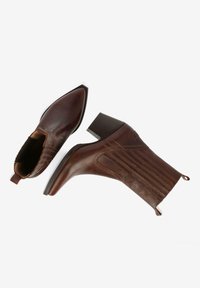 Botas de tobillo de cuero marrón con puntera afilada, tacón apilado y detalles texturizados. Presentan paneles elásticos laterales y una lengüeta.
