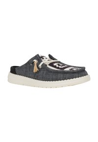 Zapato slip-on de denim con parte superior texturizada en gris oscuro y suela de goma blanca. Presenta costuras decorativas y un acento de borlas en tono marrón.