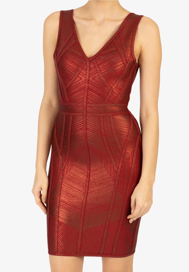 Abito bodycon rosso senza maniche con scollatura a V e motivo geometrico, indossato da una persona in piedi su uno sfondo bianco.