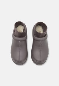 Scarpe slip-on in pelle grigia con un morbido rivestimento interno, caratterizzate da un colletto testurizzato simile a una calza e dettagli di cucitura visibili.