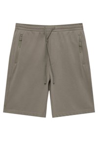 Shorts kaki en tissu texturé avec une taille élastique, un cordon de serrage réglable et deux poches latérales zippées.