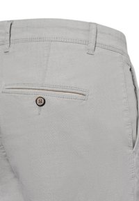 Light gray pants made of textured fabric, featuring a back pocket with a button closure and accent stitching along the pocket edge.