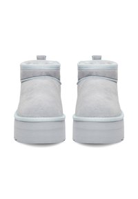 Botine gri din suede, cu talpă groasă, margine bleu deschis și tab-uri de prindere în spate, prezentate dintr-o vedere din spate pe un fundal alb.