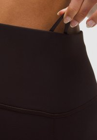 Colanți negri cu talie înaltă, confecționați dintr-un material elastic, având o suprafață netedă și detalii minime de cusătură, cu un brâu elastic.