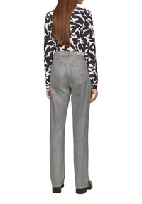 Pantalons en denim gris avec une coupe droite, dotés de deux poches arrière, d'une taille haute et de détails de couture minimalistes. Associés à un haut à motifs.