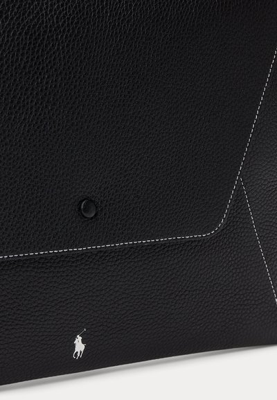 Zwarte, getextureerde leren tasklep met witte stiksels, zwarte drukknop en klein wit logo van een polospeler onderaan.