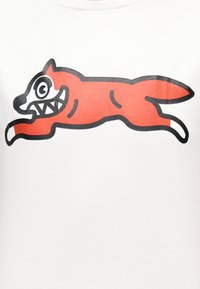 Κόκκινη καρτουνίστικη αλεπού με μεγάλα μάτια και κοφτερά δόντια, περιγραμμένη με μαύρο, που πηδά προς τα δεξιά σε λευκό φόντο.