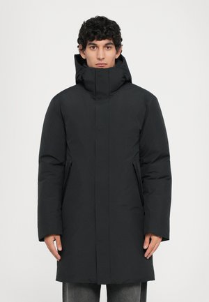 Parka nera isolata con colletto alto, bottoni a pressione e tasche laterali. Texture liscia con una finitura leggermente opaca.