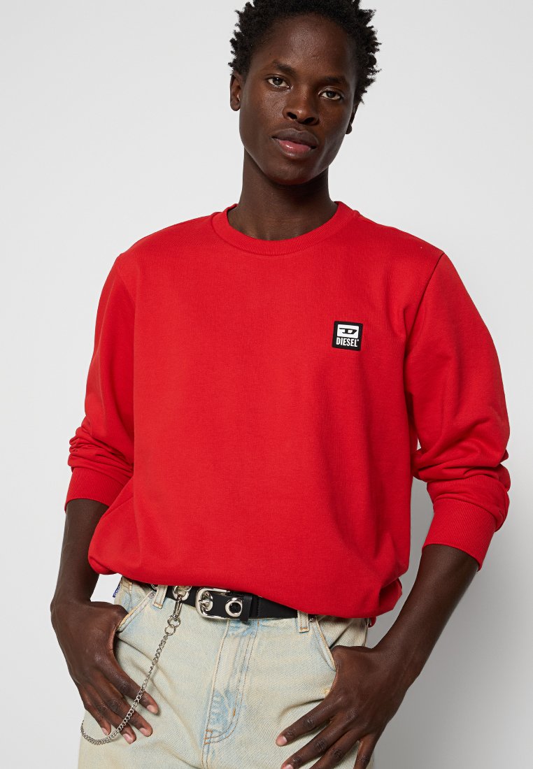 Felpa rossa realizzata in misto cotone, con maniche lunghe e scollatura rotonda. Piccolo logo Diesel in bianco e nero sul petto.