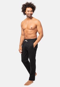 Zwarte joggingsbroek voor heren met elastische tailleband, trekkoord en zijzakken. Gemaakt van zacht materiaal, ontworpen voor comfort.