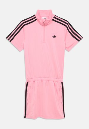 Rožinė sportinė suknelė su aukšta apykakle, trumpomis rankovėmis ir juodomis juostelėmis. Priekyje užtrauktukas ir du šoniniai kišeneliai.