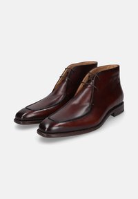 Bruine leren enkellaarsjes met een gladde afwerking, puntige neus, contrasterende stiksels en slanke vetersluiting. Ontwerp met lage, gestapelde hak.