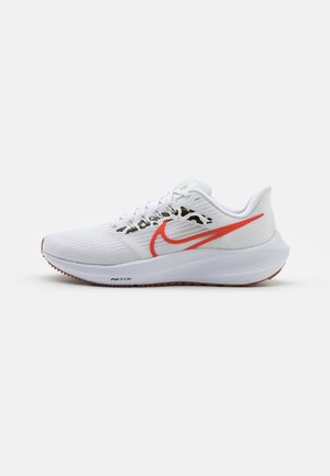 Hvid løbesko med en lys orange Nike-swoosh og leopardprint detalje over mellemsålen, vist fra siden på en ensfarvet baggrund.