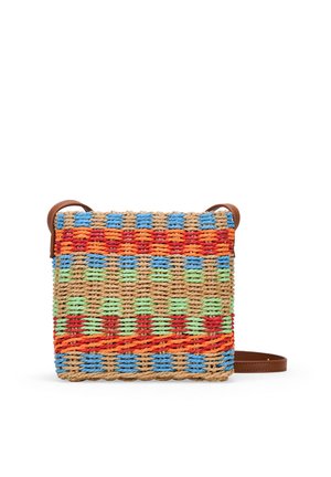 Bolso tejido multicolor con patrones azules, verdes, rojos y naranjas, con una correa de cuero marrón natural y forma cuadrada.
