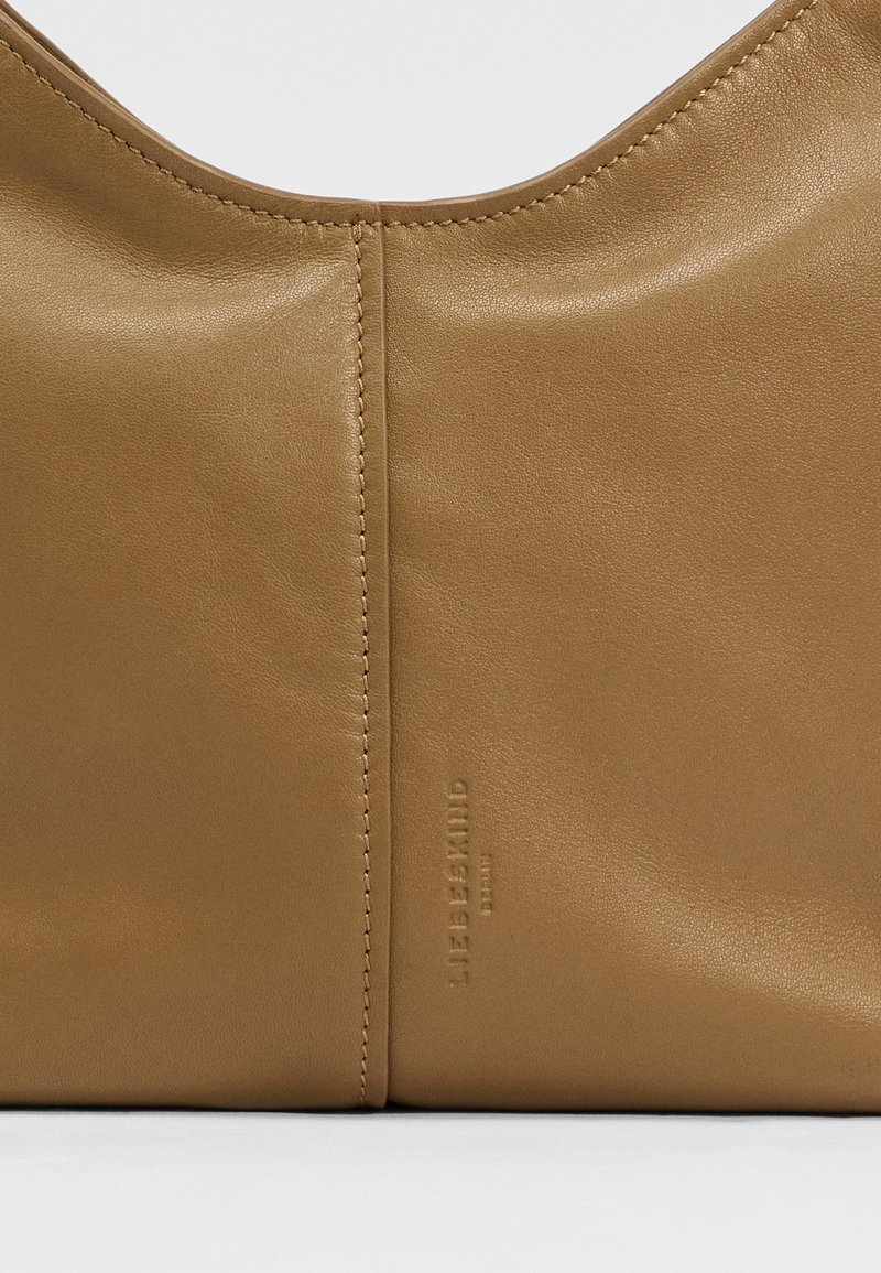 Braune Lederhandtasche mit glatter Textur, gewölbtem Oberteil und geprägtem Markennamen. Verfügt über minimale Nahtdetails entlang der Naht.