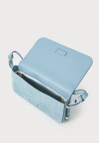 Blue leather and fabric crossbody bag with an open flap, featuring a smooth top, textured bottom, and an interior pocket. Adjustable strap.