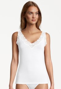 White camisole featuring a V-neckline with delicate lace trim along the straps. Smooth fabric, fitted shape, and seamless design.