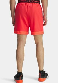 Rode sportieve shorts met een ademende mesh onderzoom en een elastische tailleband met het "Under Armour" logo. Minimalistisch ontwerp.