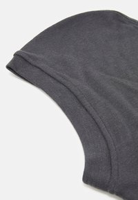 Canotta nera in cotone con una consistenza liscia, caratterizzata da un colletto rotondo e dettagli di orlo cuciti. Il tessuto è leggero e flessibile.