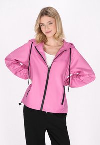 Giacca zip-up rosa chiaro con cappuccio, dettagli neri, cordini regolabili e una texture liscia e lucida; tasche sui lati.