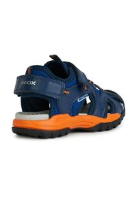 Sandales pour enfants bleu marine avec un dessus en maille et cuir, accents orange, straps réglables et une semelle en caoutchouc noir texturé.