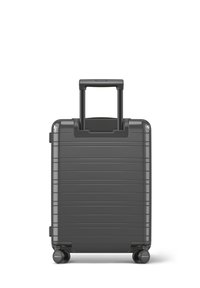 Valise rigide de couleur gris foncé avec des rainures horizontales, poignée rétractable et quatre roues pour une manœuvrabilité optimale. Texture lisse et durable.