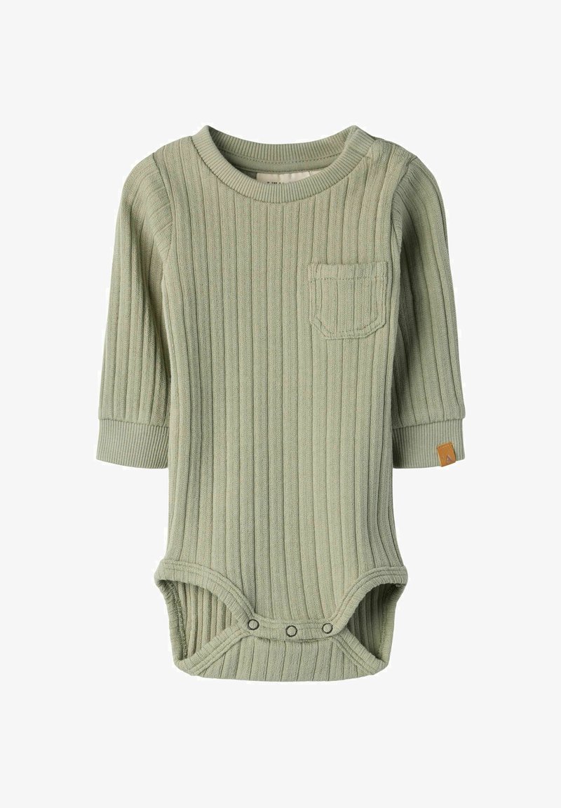 Πράσινο ριμπ μακρυμάνικο κορμάκι με μπροστινή τσέπη, κούμπωμα με πατς στο κάτω μέρος και ταμπέλα με καφέ λεπτομέρεια στο πλάι. Μαλακή υφή υφάσματος.