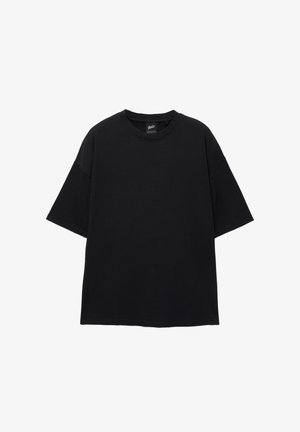 T-shirt nera oversize con maniche corte, scollo rotondo, realizzata in stoffa di cotone. Design semplice senza motivi o accenti visibili.