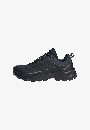 Scarpa da trekking nera con parte superiore in rete e materiali sintetici, suola robusta, strato di ammortizzazione e lacci neri. Presenta un grande logo del marchio sul lato.