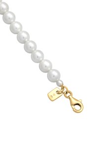 Vit pärlhalsband med runda pärlor. Har en guldkrok och ett märke med ingraverad detalj. Slät yta och enhetlig form genomgående.