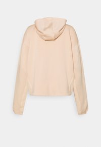 Sweat à capuche court couleur pêche avec cordon de serrage, poignets de manches côtelés et texture lisse, présentant une coupe décontractée et des détails de coutures latérales.