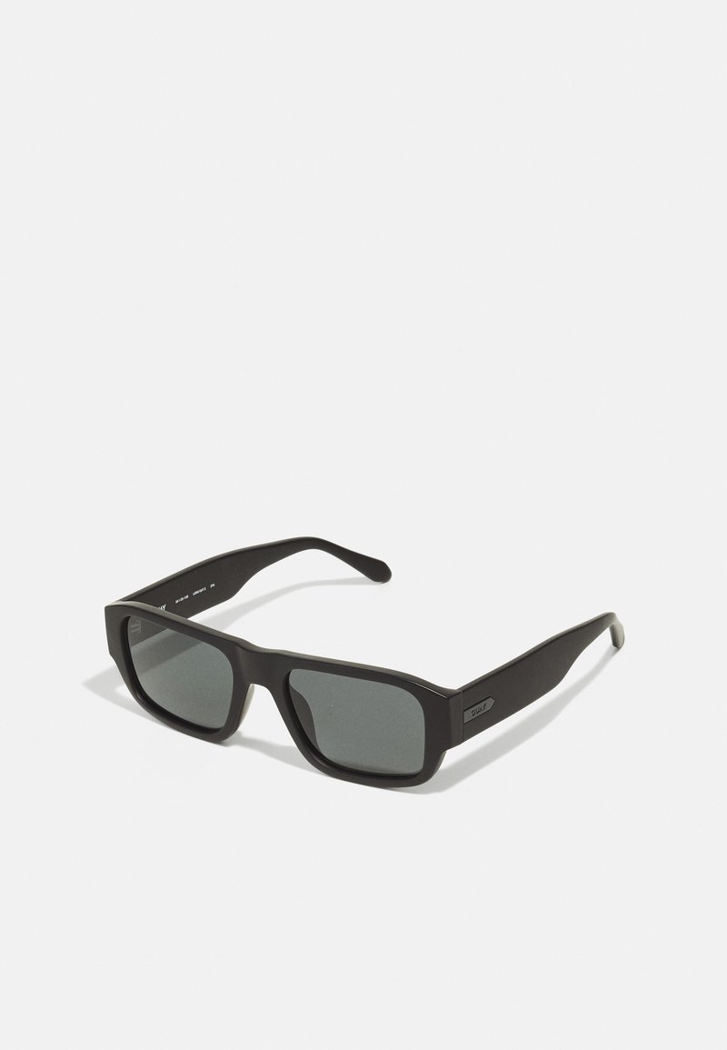 Gafas de sol rectangulares negras con lentes tintados y textura mate. Cuentan con patas anchas y un logo discreto en el lateral.