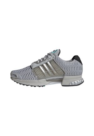 Grå atletisk sneaker med mesh øverdel, klar plaststøttepanel, hvid mellemsål og sorte samt sølvfarvede detaljer på ydersålen.
