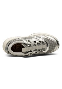 Grå atletisk sko med ovandel i mesh, metalliska detaljer, elastiska snören och en dämpad sula med strukturerad yta. Varumärkeslogotyp närvarande.