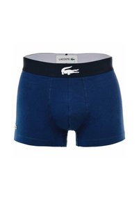Boxers en bleu marine en mélange de coton. Présentent une taille noire avec le logo Lacoste blanc. Texture lisse, design ajusté.