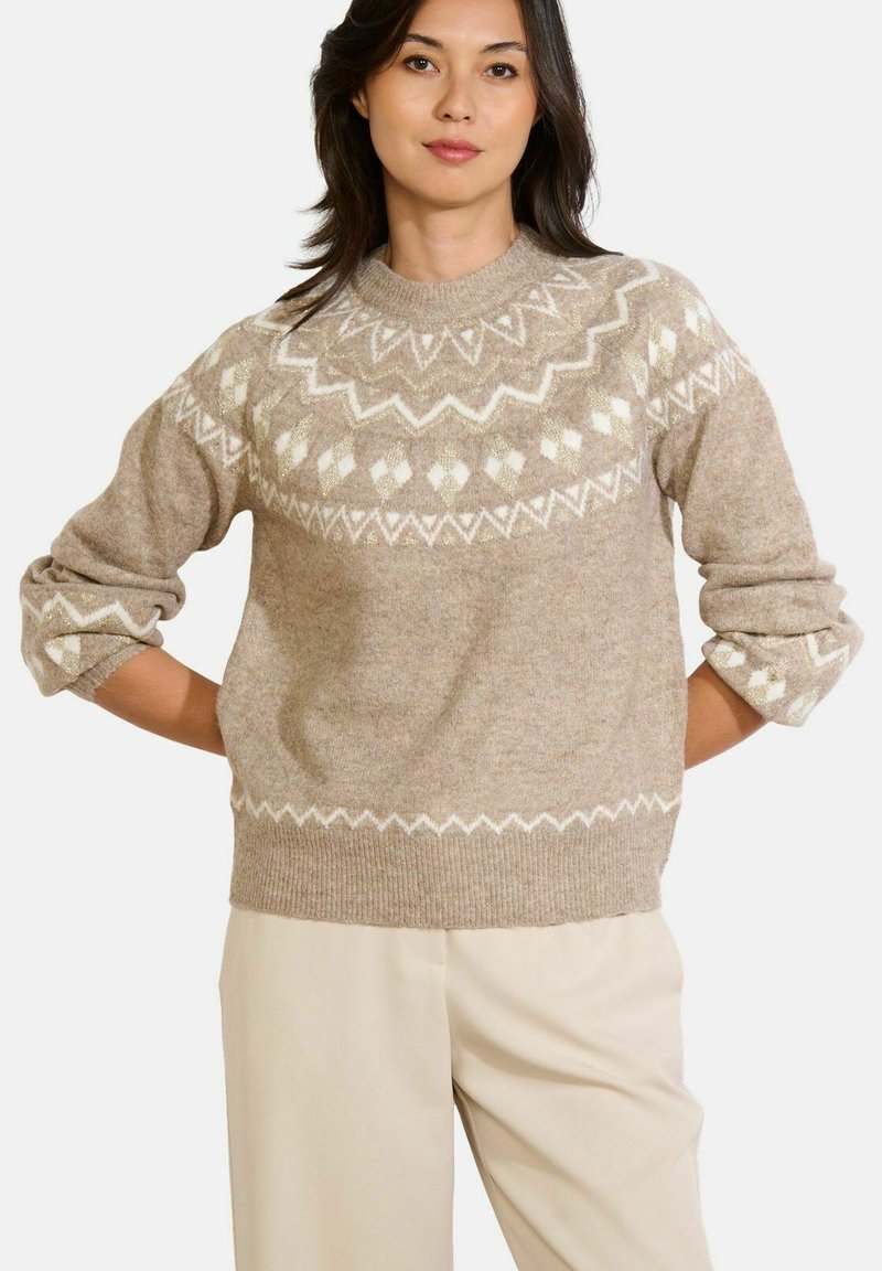 Beige Strickpullover mit geometrischen weißen Mustern und einem runden Ausschnitt. Verfügt über einen strukturierten Stoff und leicht übergroße, hochgekrempelte Ärmel.
